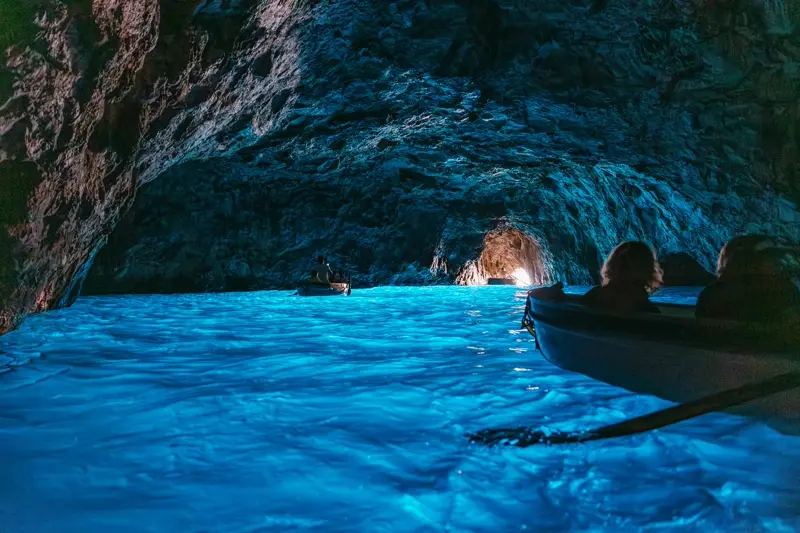 The electric-blue glow inside Capri's Blue Grotto with a rowboat silhouette