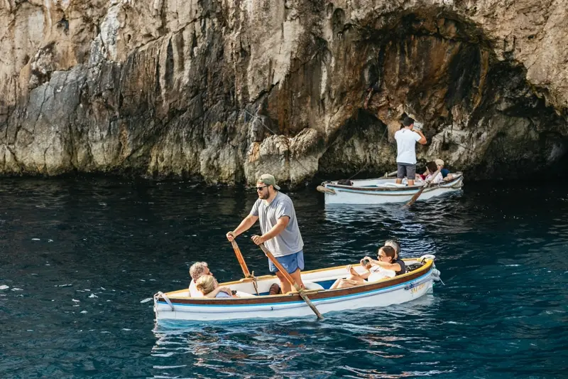 Traditional wooden rowboats waiting at the Blue Grotto entrance